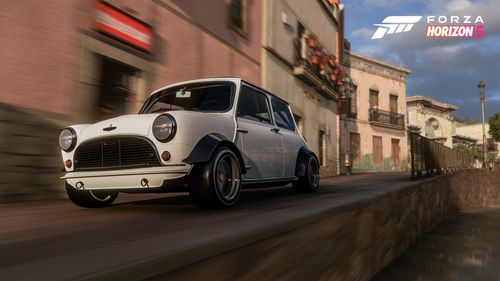 A white Mini Cooper Forza Edition zooms through a tight road in the city of Guanajuato.