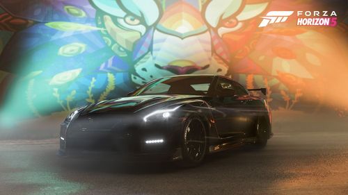 A black Nissan GT-R NISMO parked in front of the colorful Farid Rueda Lion Mural.