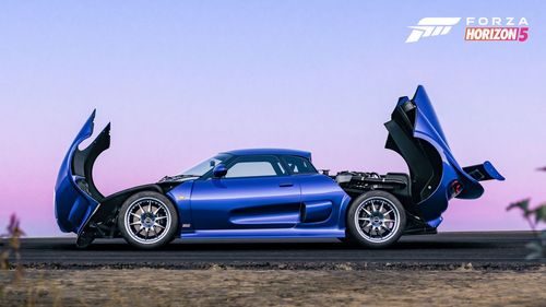 A side view of a blue Noble M400 opens its front and rear casing to reveal its engine with a purple hue in the sky.