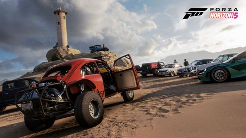 A Convoy of drivers park up their vehicles on a beach by a lighthouse. There's a red buggy and a green supercar amongst the collection.
